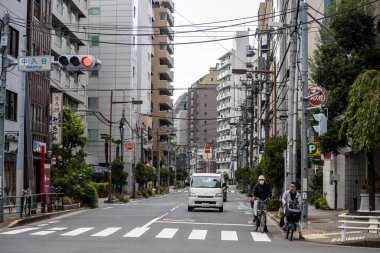 Tokyo, Japonya, 28 Ekim 2023: Tokyo 'da yolları paylaşan bisikletçiler ve arabalar
