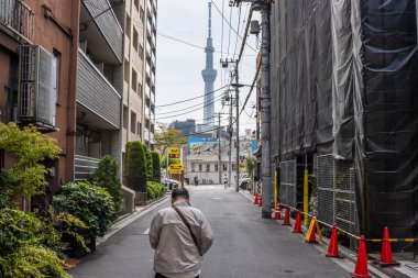 Tokyo, Japonya, 28 Ekim 2023: Uzak mesafeden Tokyo 'ya doğru yürüyen adam