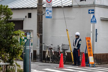 Tokyo, Japonya, 28 Ekim 2023: İnşaat alanında trafiği yöneten işçi