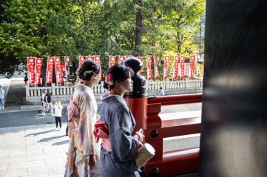 Tokyo, Japan, 28 October 2023: Women in traditional kimonos walking along the temple balcony clipart