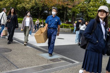 Tokyo, Japonya, 28 Ekim 2023: Yaya geçitleri okul kızıyla karşıdan karşıya geçiyor