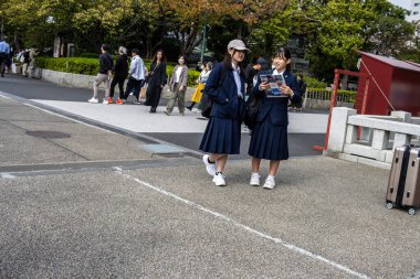 Tokyo, Japonya, 28 Ekim 2023: Okul kızları güneşli bir günün tadını çıkarıyor
