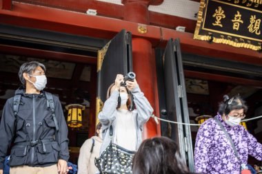 Tokyo, Japonya, 28 Ekim 2023: Tapınak girişinde maske takan ziyaretçiler