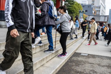 Tokyo, Japonya, 28 Ekim 2023: Sıradan giyinen gençler sokakta yürüyor