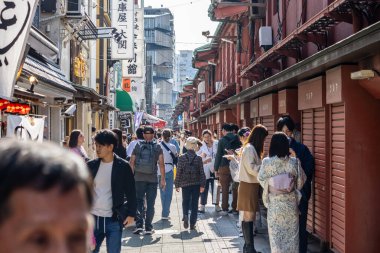 Tokyo, Japonya, 28 Ekim 2023: Asakusa 'da alışverişçiler ve geleneksel mağazalarla dolu kalabalık bir ara sokak