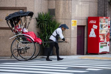 Tokyo, Japonya, 28 Ekim 2023: Rickshaw çekicisi otomatın yanında yolcu bekliyor