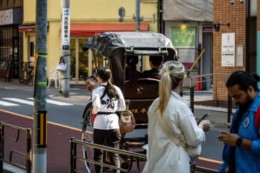 Tokyo, Japonya, 28 Ekim 2023: Geleneksel triportör çekicisi Asakusa 'da turistlerle etkileşimde