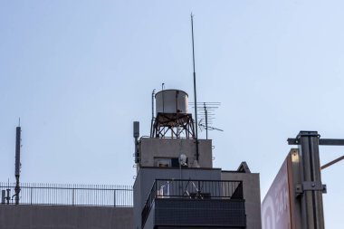 Tokyo, Japonya, 28 Ekim 2023: Şehir siluetine karşı çatıdaki su tankı