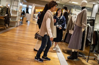 Tokyo, Japonya, 28 Ekim 2023: Alışverişçilerin Moda Perakende Mağazasında Giysileri İncelemesi