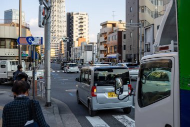 Tokyo, Japonya, 28 Ekim 2023: Araçlar ve yayalarla dolu şehir caddesi
