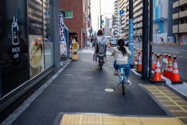 Tokyo, Japonya, 28 Ekim 2023 Bir inşaat alanının yanındaki bisiklet yolunda bisikletçiler