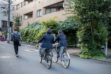 Tokyo, Japonya, 28 Ekim 2023: Yeşil Şehir Yolu boyunca Bisikletçiler