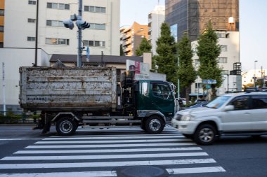 Tokyo, Japonya, 28 Ekim 2023: Yaya geçidinden geçen çöp kamyonu