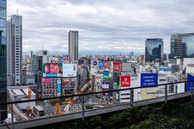 Tokyo, Japonya, 29 Ekim 2023: Reklam panoları ve yükseltilmiş yürüyüş yolu olan şehir manzarası