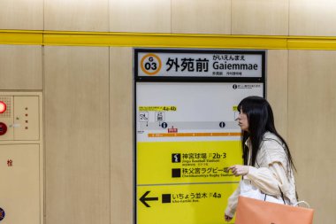 Tokyo, Japonya, 29 Ekim 2023: Metro istasyonunda yön işaretinin yanındaki banliyö