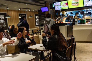 Tokyo, Japonya, 29 Ekim 2023: Müşteriler bir fast food restoranında sosyalleşiyor