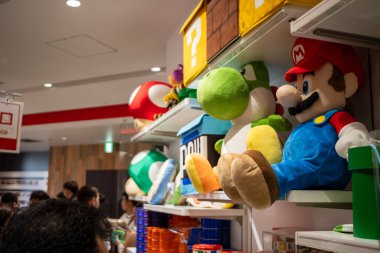 Tokyo, Japonya, 29 Ekim 2023: Müşteriler Mario pelüş oyuncak vitrininin yakınındaki ürünlere göz atıyorlar