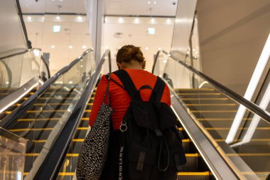Tokyo, Japonya, 29 Ekim 2023: Modern Tokyo binasında yürüyen merdivende yükselen kadın