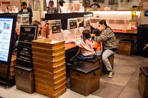 Токио, Япония, 29 октября 2023 года: Повседневная трапеза в современной закусочной Токио с клиентами и персоналом