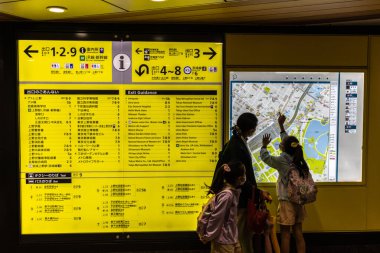 Tokyo, Japonya, 29 Ekim 2023: Tren çizelgesine bakan banliyö sakinleri