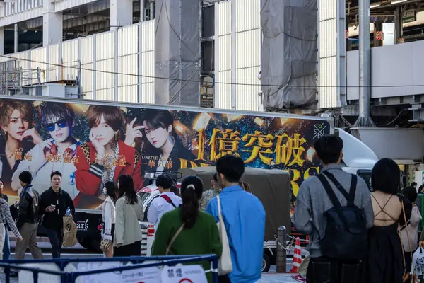 Tokyo, Japonya, 29 Ekim 2023: Kalabalık büyük bir reklam panosunu izliyor