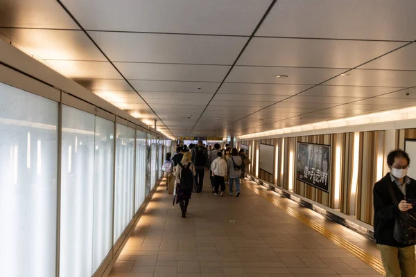 Tokyo, Japonya, 29 Ekim 2023: İyi aydınlatılmış bir metro koridorunda yürüyen insanlar