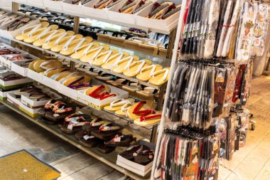 Tokyo, Japonya, 29 Ekim 2023: Bir hediyelik eşya dükkanındaki raflarda düzgün düzenlenmiş Japon 'zori' sandaletleri