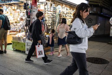 Tokyo, Japonya, 29 Ekim 2023: Asakusa 'da canlı bir caddede çeşitli mağazaların önünden geçen yayalar