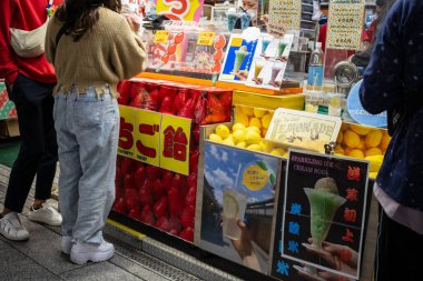 Tokyo, Japonya, 29 Ekim 2023: Tokyo pazarındaki renkli bir meyve standında alışveriş yapanlar