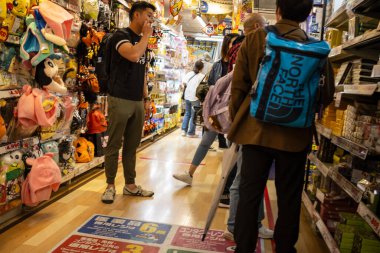 Tokyo, Japonya, 29 Ekim 2023: Tokyo 'da kalabalık bir Don Kişot mağazası koridorunu keşfeden müşteriler