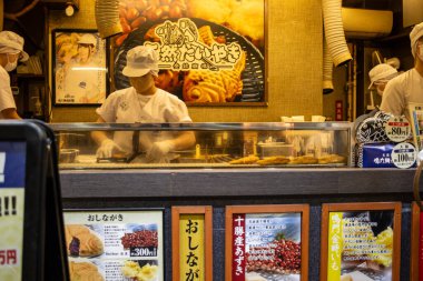 Tokyo, Japonya, 29 Ekim 2023: Yoğun bir Japon restoranında aşçılar tezgahın arkasında yemek hazırlıyorlar