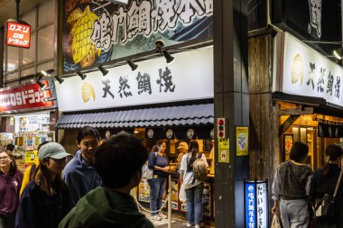 Tokyo, Japonya, 29 Ekim 2023: Geceleri popüler bir Japon restoranının önünde kuyrukta bekleyen müşteriler