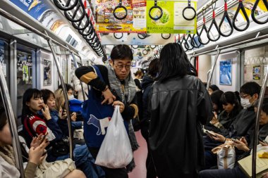 Tokyo, Japonya, 29 Ekim 2023: Kalabalık bir Tokyo metro vagonundaki yolcular