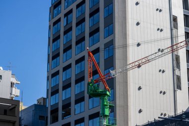 Tokyo, Japonya, 30 Ekim 2023: Modern bir binanın arka planına karşı inşaat vinci