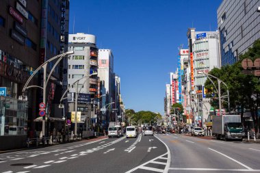Tokyo, Japonya, 30 Ekim 2023: Tokyo 'da ticari binalar ve açık mavi gökyüzü ile geniş cadde