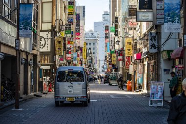 Tokyo, Japonya, 30 Ekim 2023: Dar Tokyo Caddesi 'nde küçük teslimat aracı