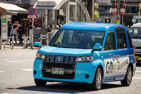 Tokyo, Japonya, 30 Ekim 2023: Tokyo 'nun işlek caddelerinde sürüş yapan kompakt mavi araba