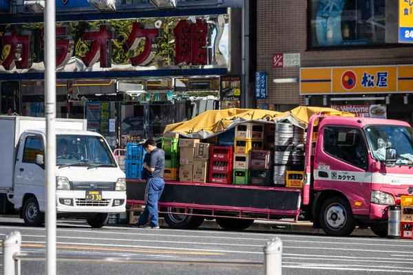 Tokyo, Japonya, 30 Ekim 2023: Malları Tokyo 'daki kalabalık bir pazar alanında bir kamyona yükleyen tedarikçi