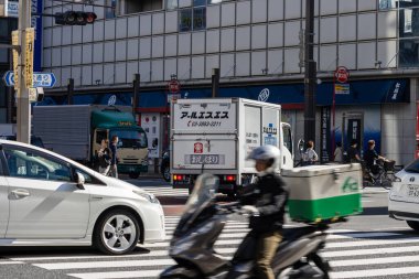 Tokyo, Japonya, 30 Ekim 2023: Tokyo kavşağında teslimat motosikleti ve trafik