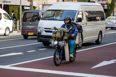 Tokyo, Japonya, 30 Ekim 2023: Tokyo caddesinde kargolu motosikletçi