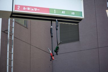 Tokyo, Japonya, 30 Ekim 2023: Tokyo 'daki bir benzin istasyonunda dikey yakıt pompası hortumları