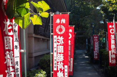 Tokyo, Japonya, 30 Ekim 2023: Japon karakterli canlı kırmızı pankartlar bir tapınak girişinde
