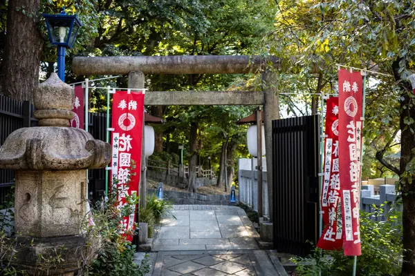 Tokyo, Japonya, 30 Ekim 2023: Geleneksel fener ve afişlerle bir Shinto tapınağının Torii kapısı girişi