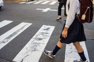 Tokyo, Japonya, 30 Ekim 2023: Zebra geçidinde karşıdan karşıya geçen kişi