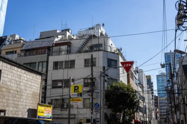 Tokyo, Japonya, 30 Ekim 2023: Tokyo 'da açık mavi gökyüzü olan şehir otoparkı ve binalar