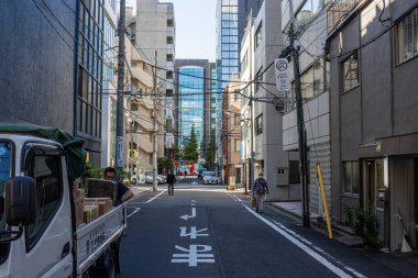 Tokyo, Japonya, 30 Ekim 2023: Tokyo 'da bisikletli ve nakliye kamyonu olan şehir sokağı