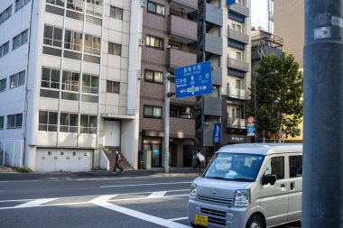 Tokyo, Japonya, 30 Ekim 2023: Şehir caddesinde bir kavşaktan geçen minibüs