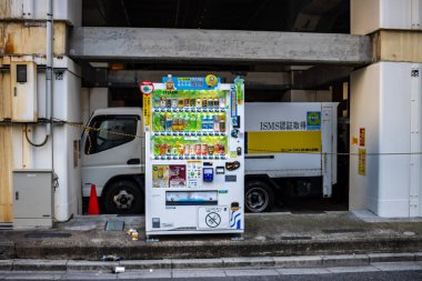 Tokyo, Japonya, 30 Ekim 2023: Otomat köşesinde park etmiş bir teslimat kamyonunun yanında.