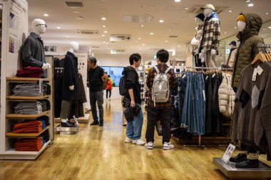 Tokyo, Japonya, 30 Ekim 2023: Müşteriler bir mağazadaki erkek giyim reyonuna göz atıyorlar