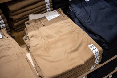 Tokyo, Japonya, 30 Ekim 2023: Bir giyim mağazasında stoklanmış chinolar